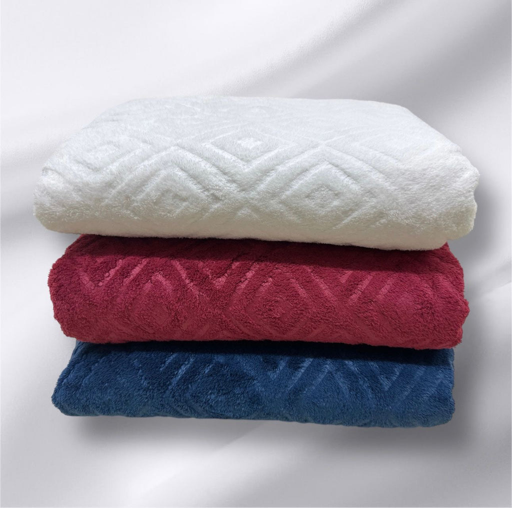 Stack of three folded towels in white, red, and blue on a light gray background
