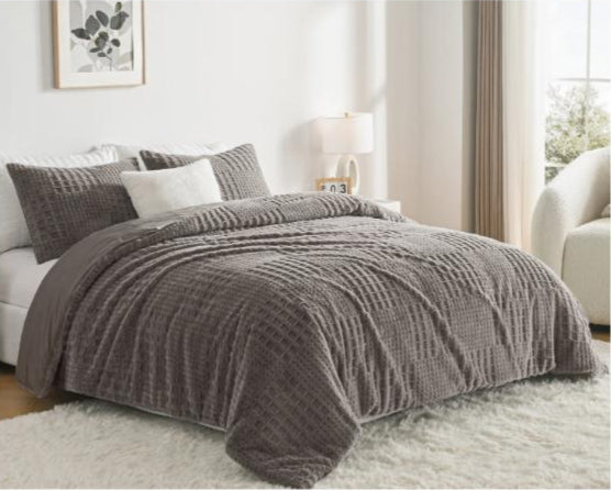 Gray textured comforter on a bed in a bedroom setting