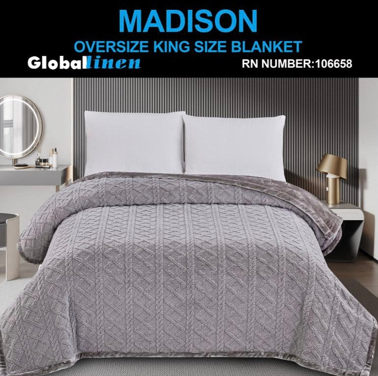 Gray quilt on a bed with 'Madison' branding and product details.