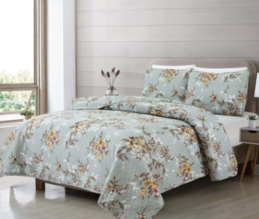 Floral bedding set on a bed in a bedroom with a window and side table.