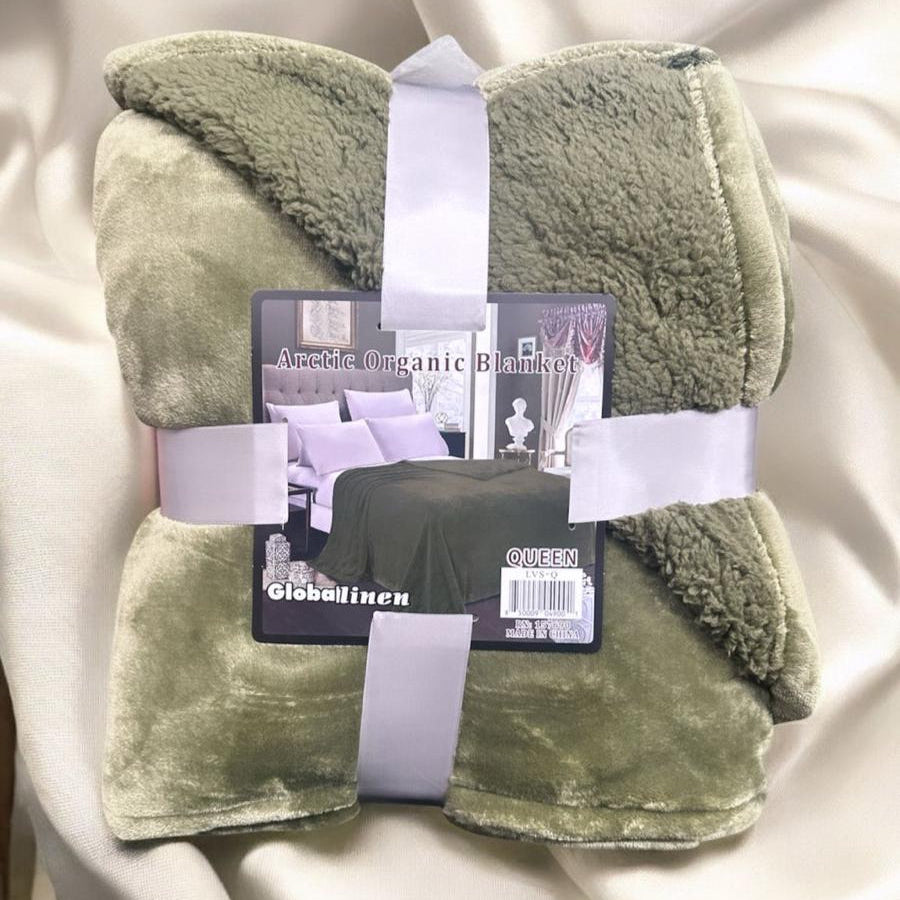 Green blanket with a visible brand label on a white background